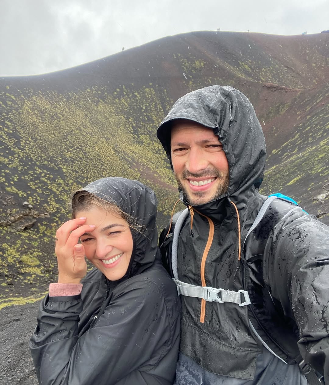 Jeta and Ali on a mountain, laughing in the rain